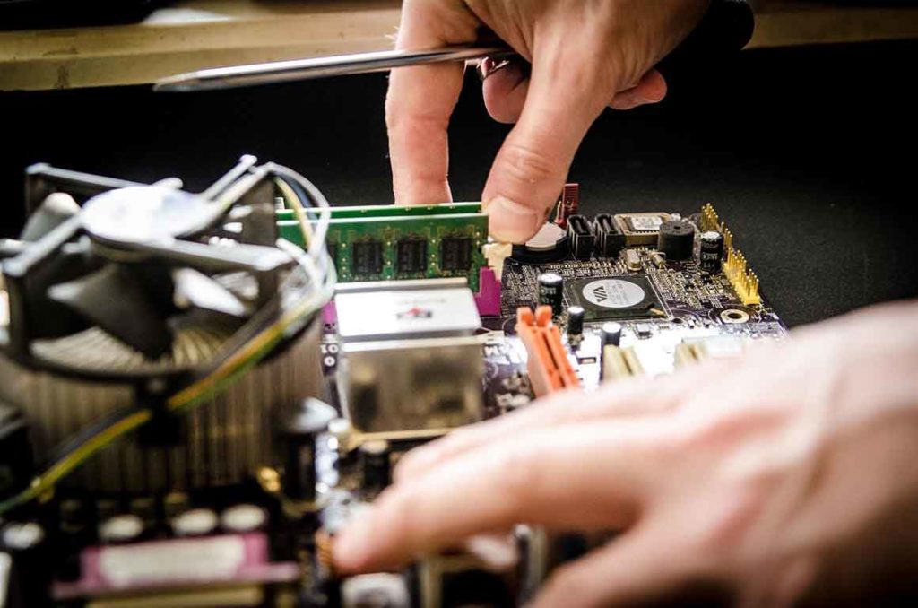 Das Bild zeigt den Einbau von RAM Speichermodulen auf einem älteren Mainboard